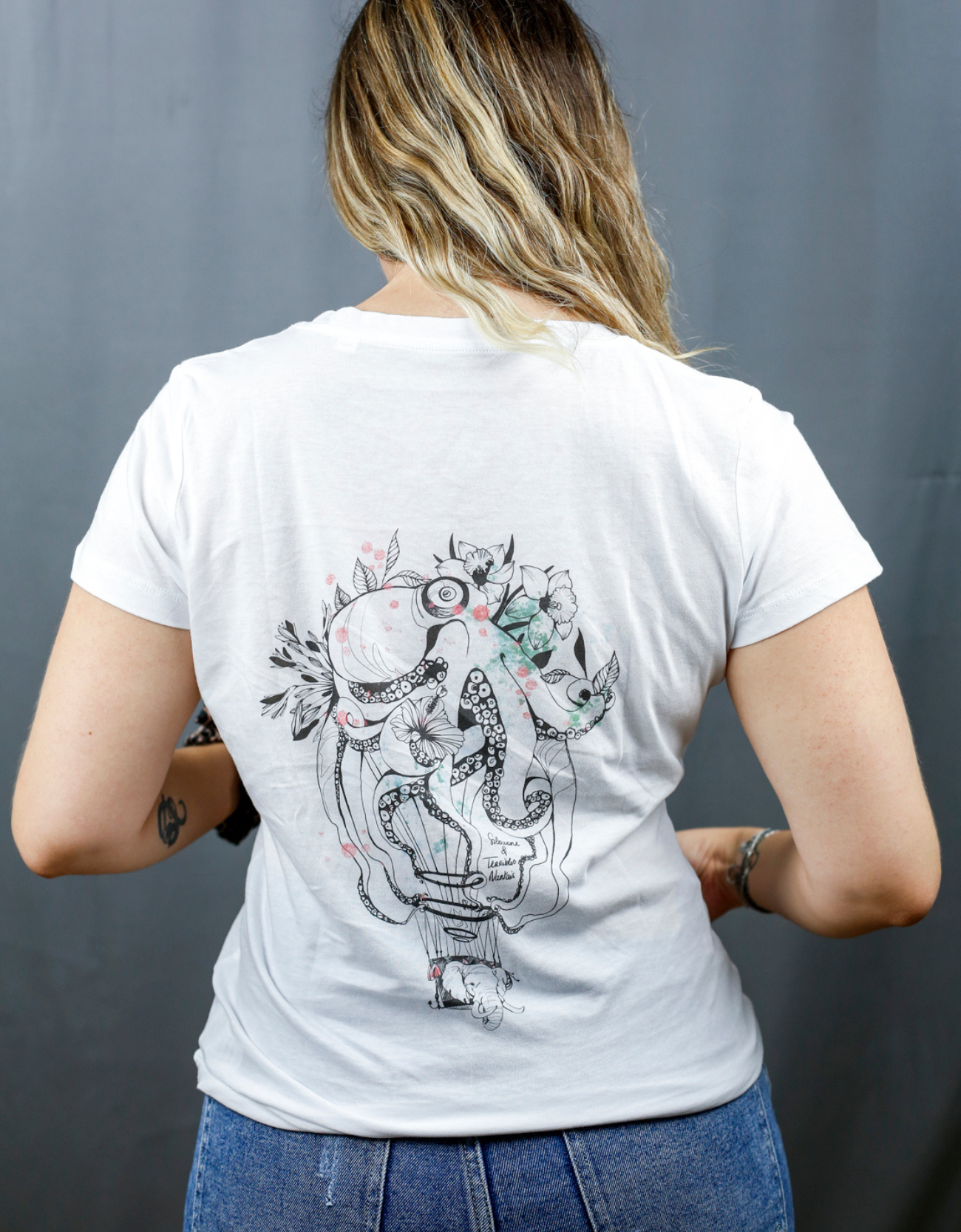 Femme avec T-Shirt blanc à col V et visuel noir, vert et rouge de la marque Terribles Nantais