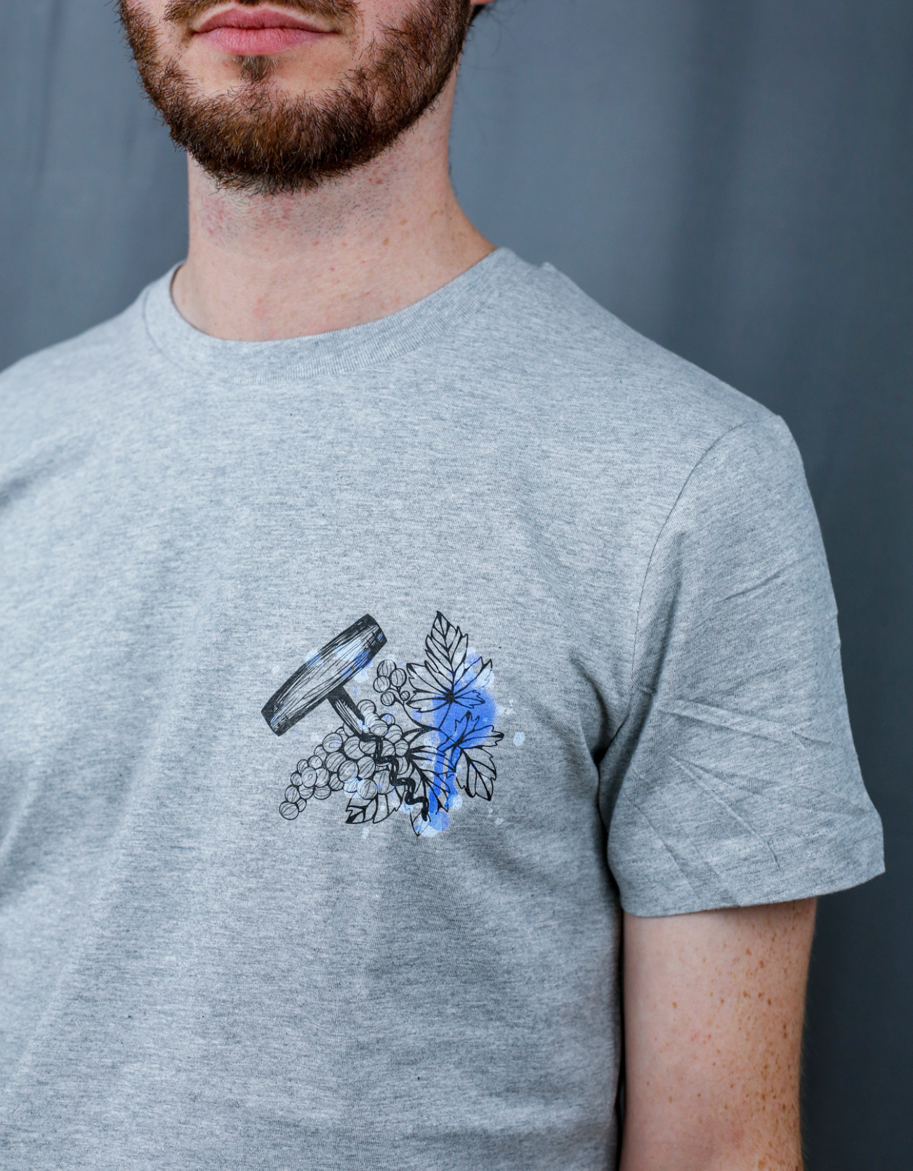 Homme avec T-Shirt gris à col rond et visuel noir, bleu et bleu clair de la marque Terribles Nantais