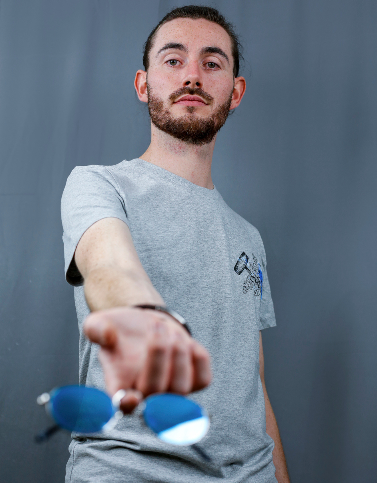 Homme avec T-Shirt gris à col rond et visuel noir, bleu et bleu clair de la marque Terribles Nantais