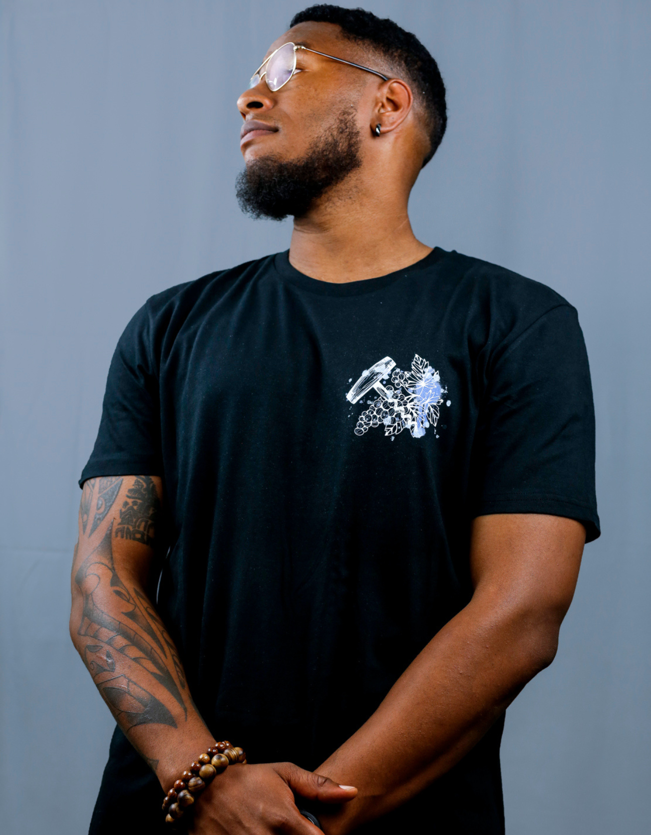 Homme avec T-Shirt noir à col rond et visuel blanc, bleu et bleu clair de la marque Terribles Nantais