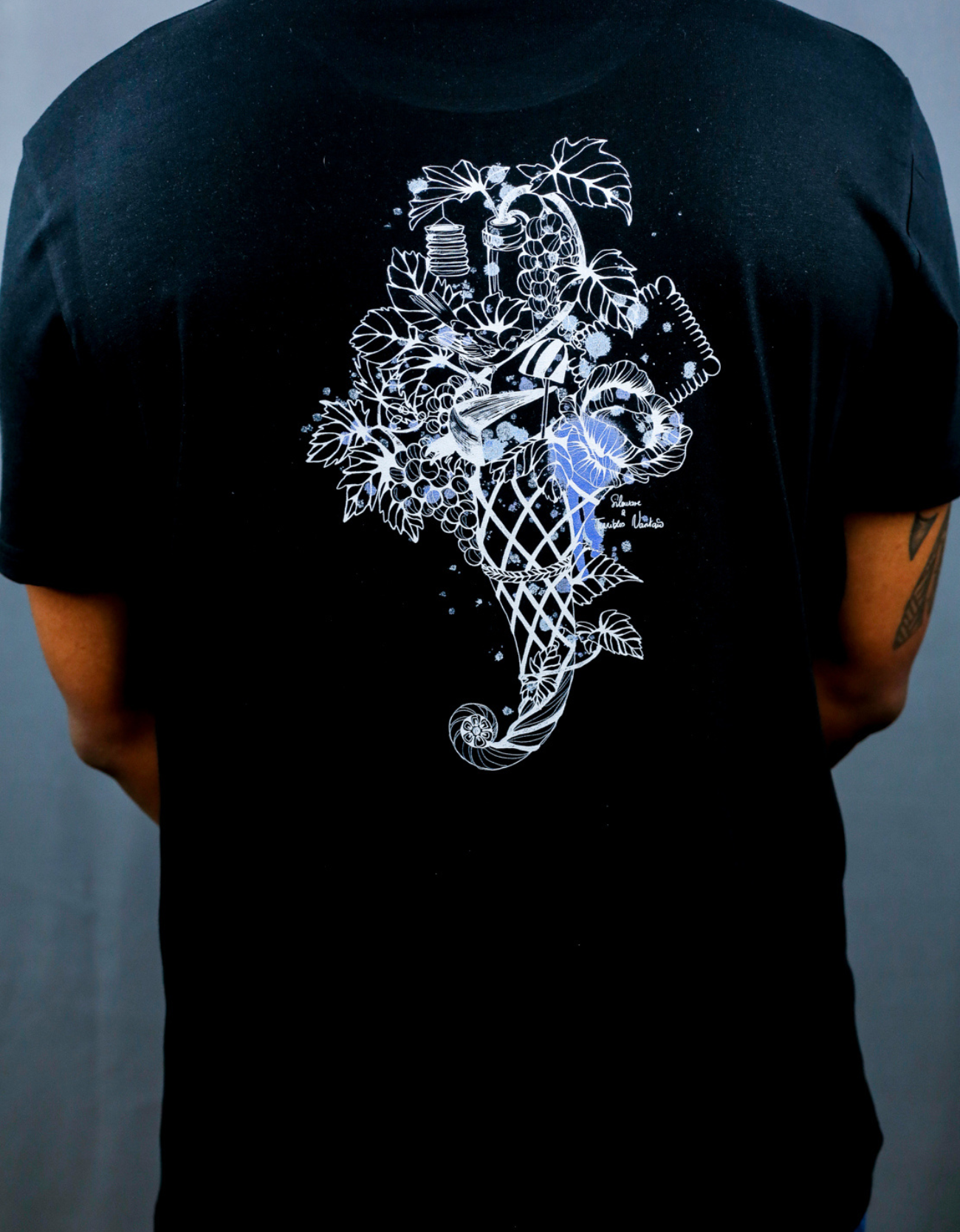 Homme avec T-Shirt noir à col rond et visuel blanc, bleu et bleu clair de la marque Terribles Nantais