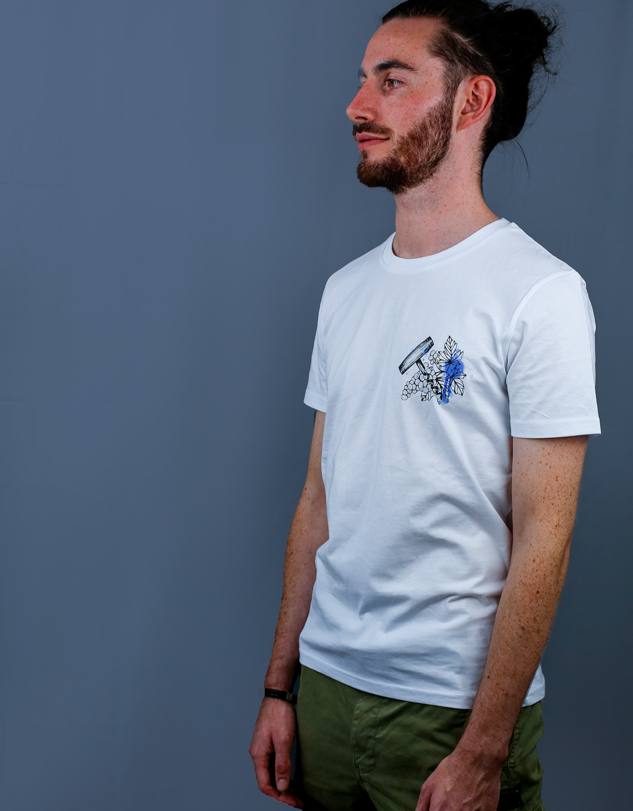 Homme avec T-Shirt blanc à col rond et visuel noir, bleu et bleu clair de la marque Terribles Nantais
