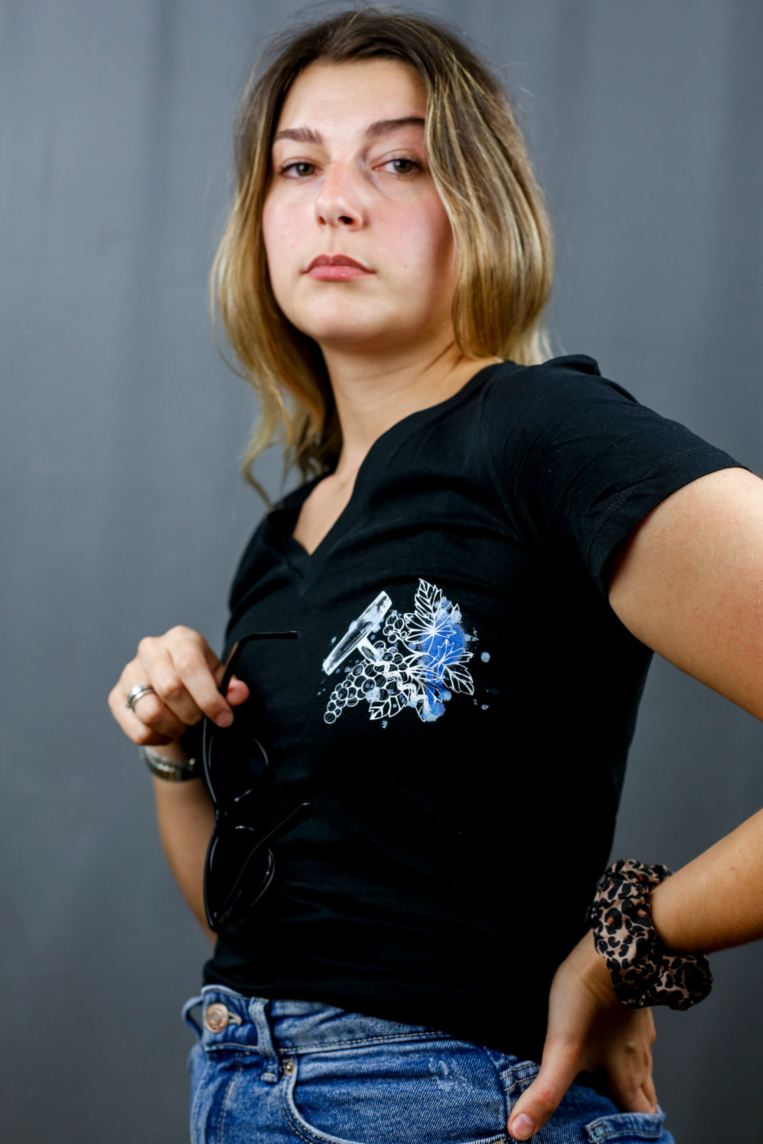 Femme avec T-Shirt noir à col V et visuel noir, bleu et bleu clair de la marque Terribles Nantais