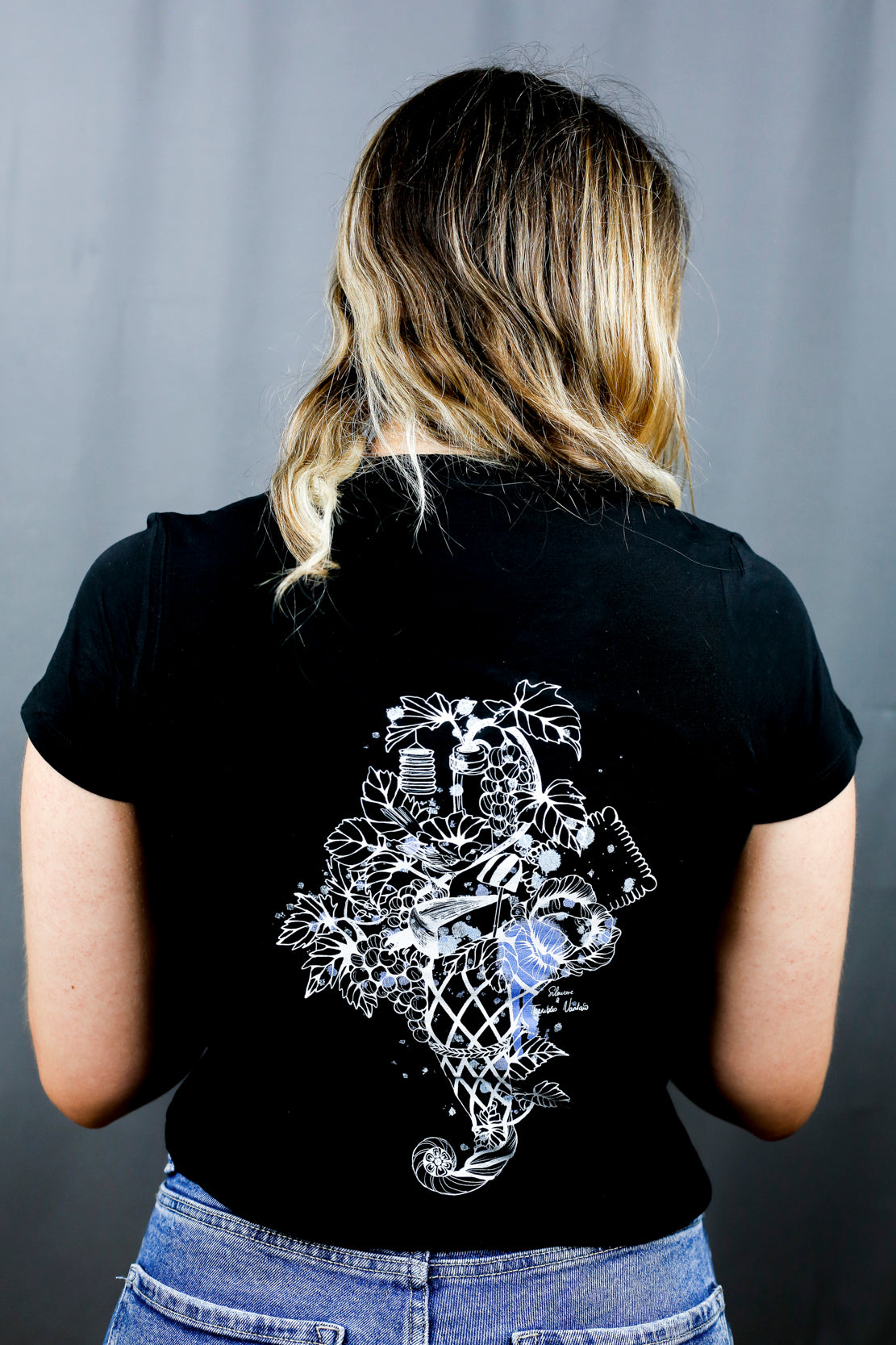 Femme avec T-Shirt noir à col V et visuel noir, bleu et bleu clair de la marque Terribles Nantais