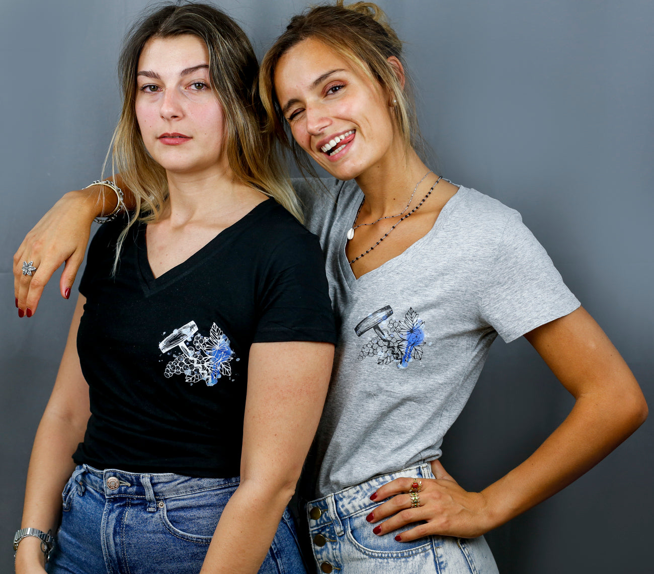 Deux Femmes avec des T-Shirts gris et noirs à col V et visuel noir, bleu et bleu clair de la marque Terribles Nantais